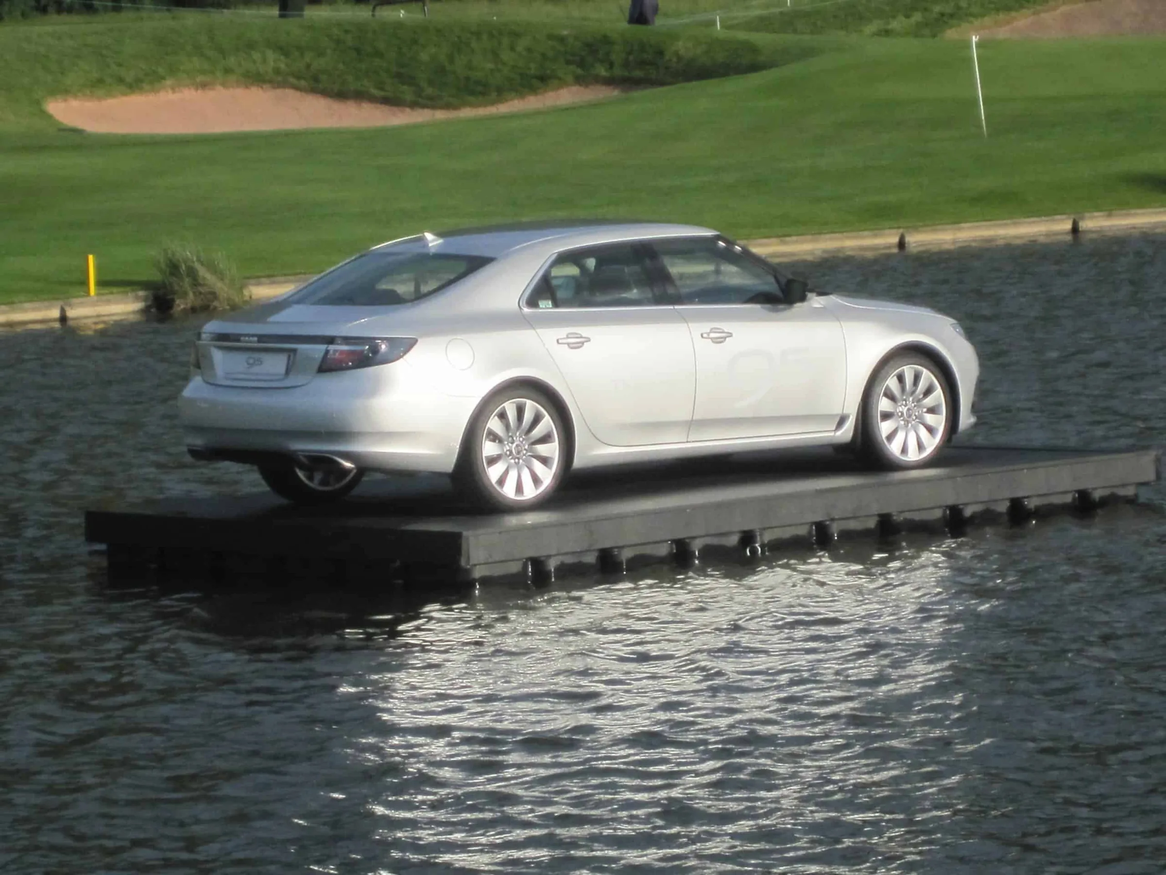 Auto auf einem Jetfloat Ponton auf einem Golfplatz-Teich
